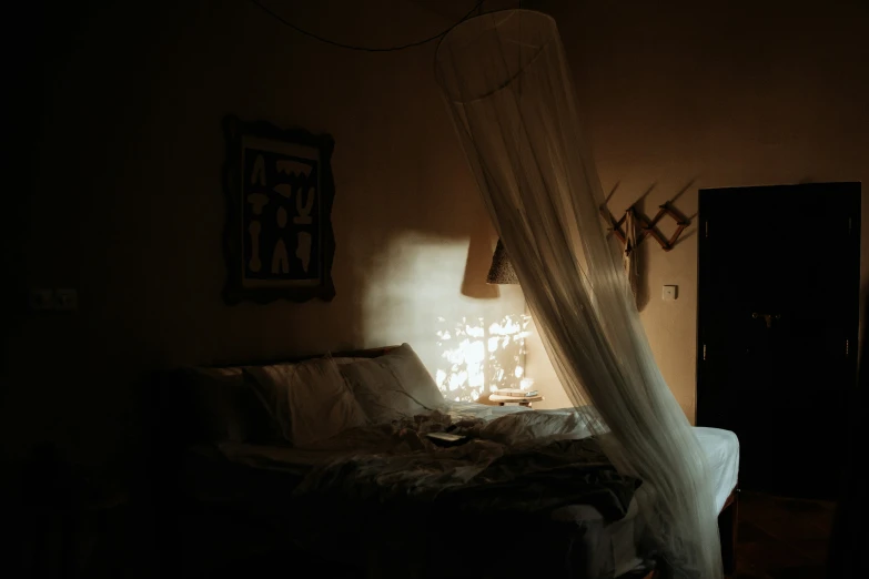 a dimly lit bed with a white blanket on it
