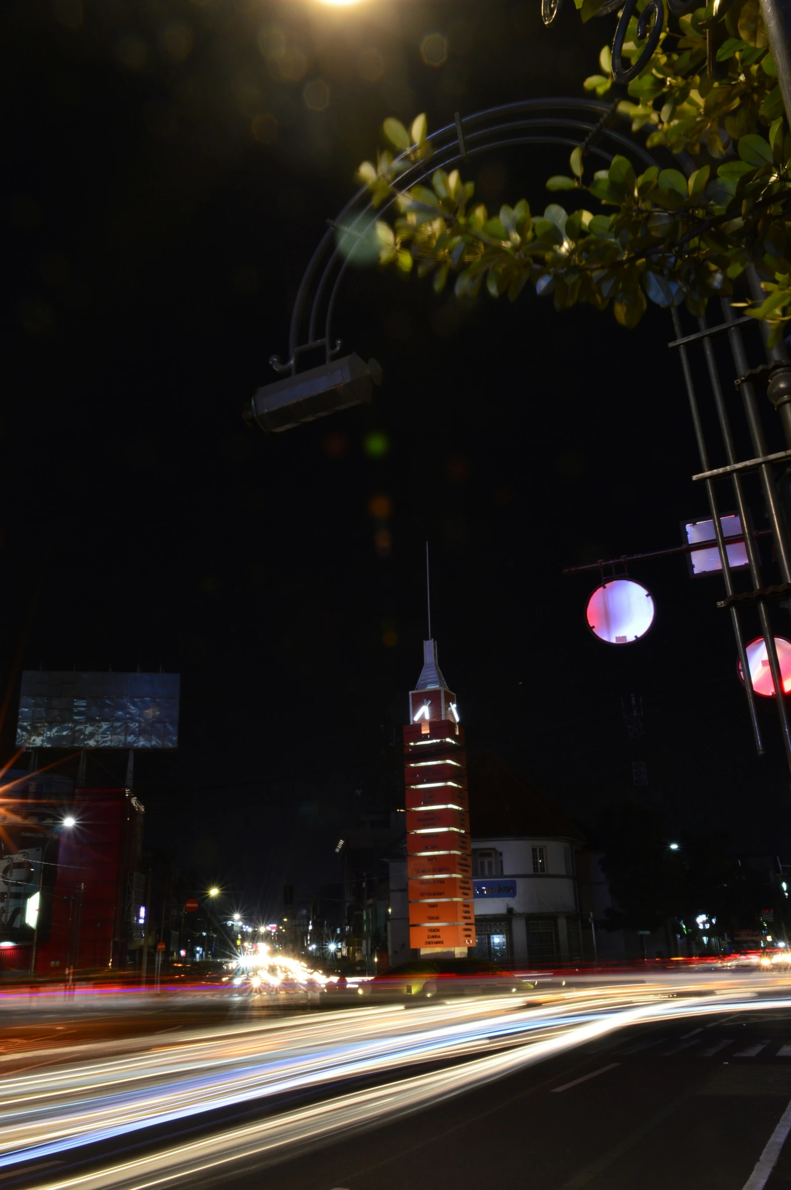 a night view of a clock tower near lights