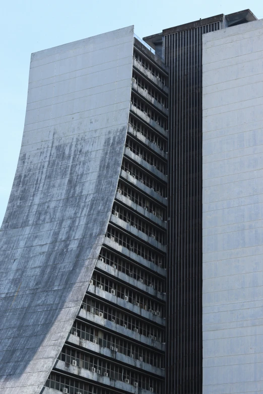 a very tall building in front of a building made of sheets