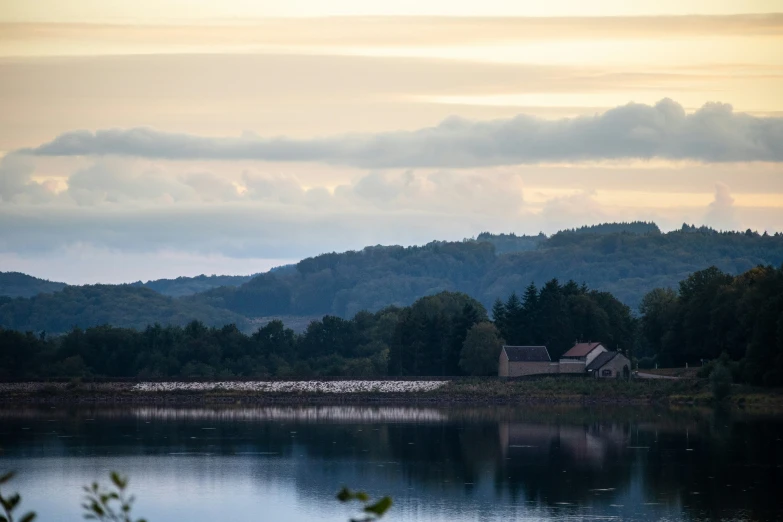 view of hills with trees and houses by water