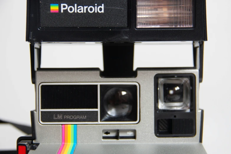 an old polaroid camera with the lens up showing a rainbow