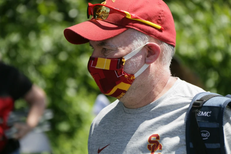 an older man wearing a red hat and some yellow lines on his face