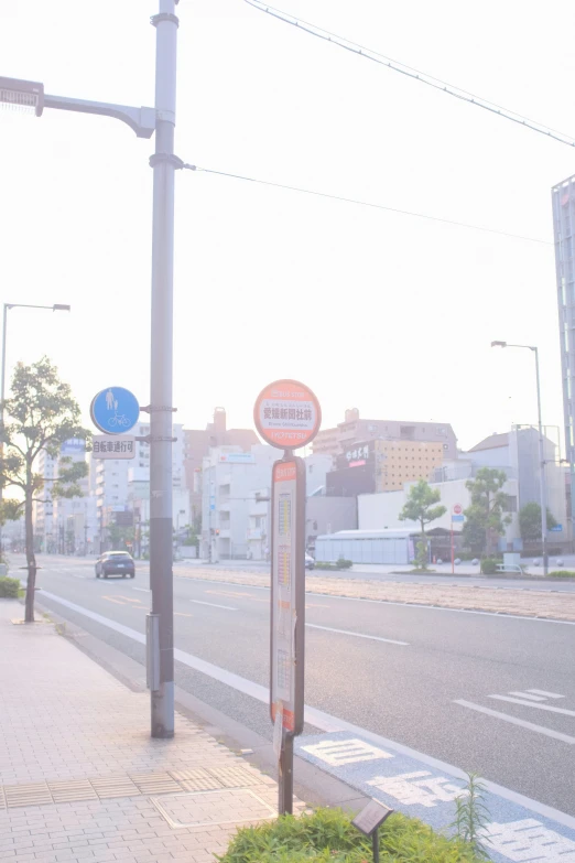 an intersection with a road, signs, and buildings in the background