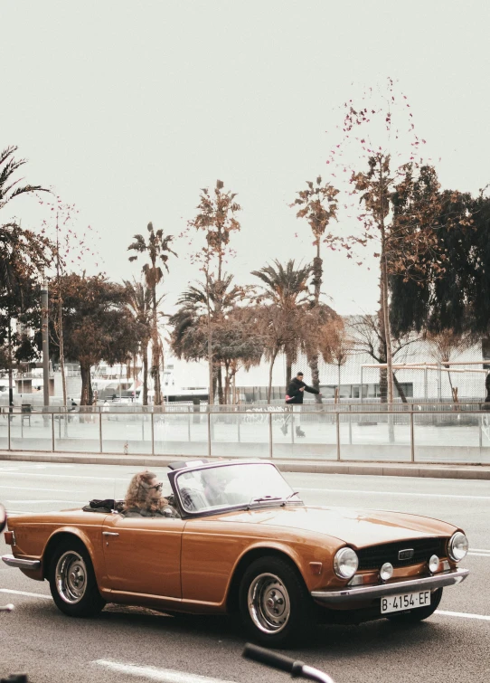 a classic car drives down the street of an empty parking lot