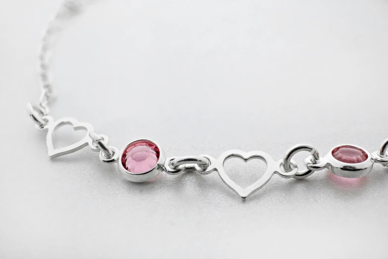 a silver celet with heart shaped charms attached