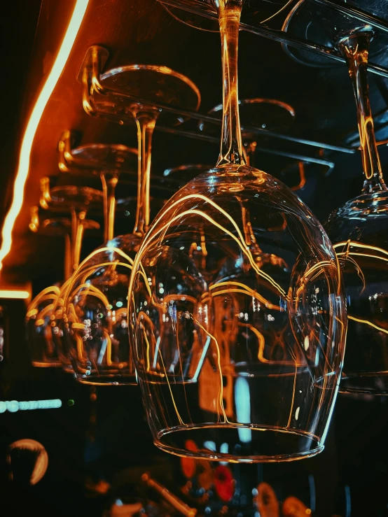 a bunch of wine glasses that are hanging in the ceiling