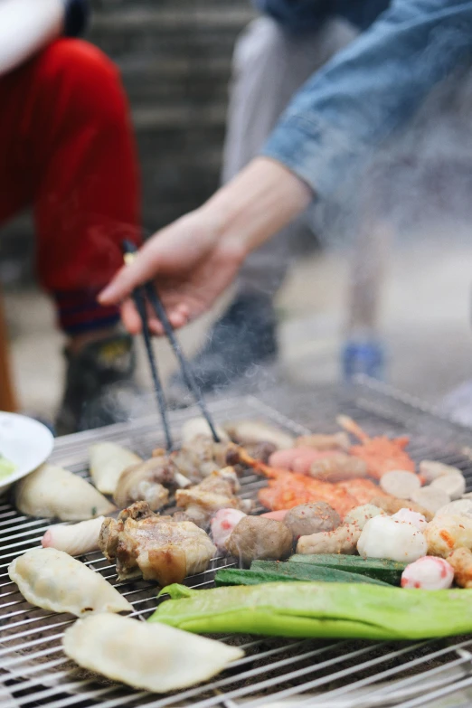 someone cooking food on top of the grill