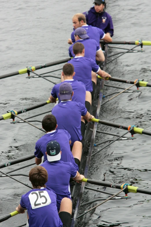 men are rowing in row boats across the water