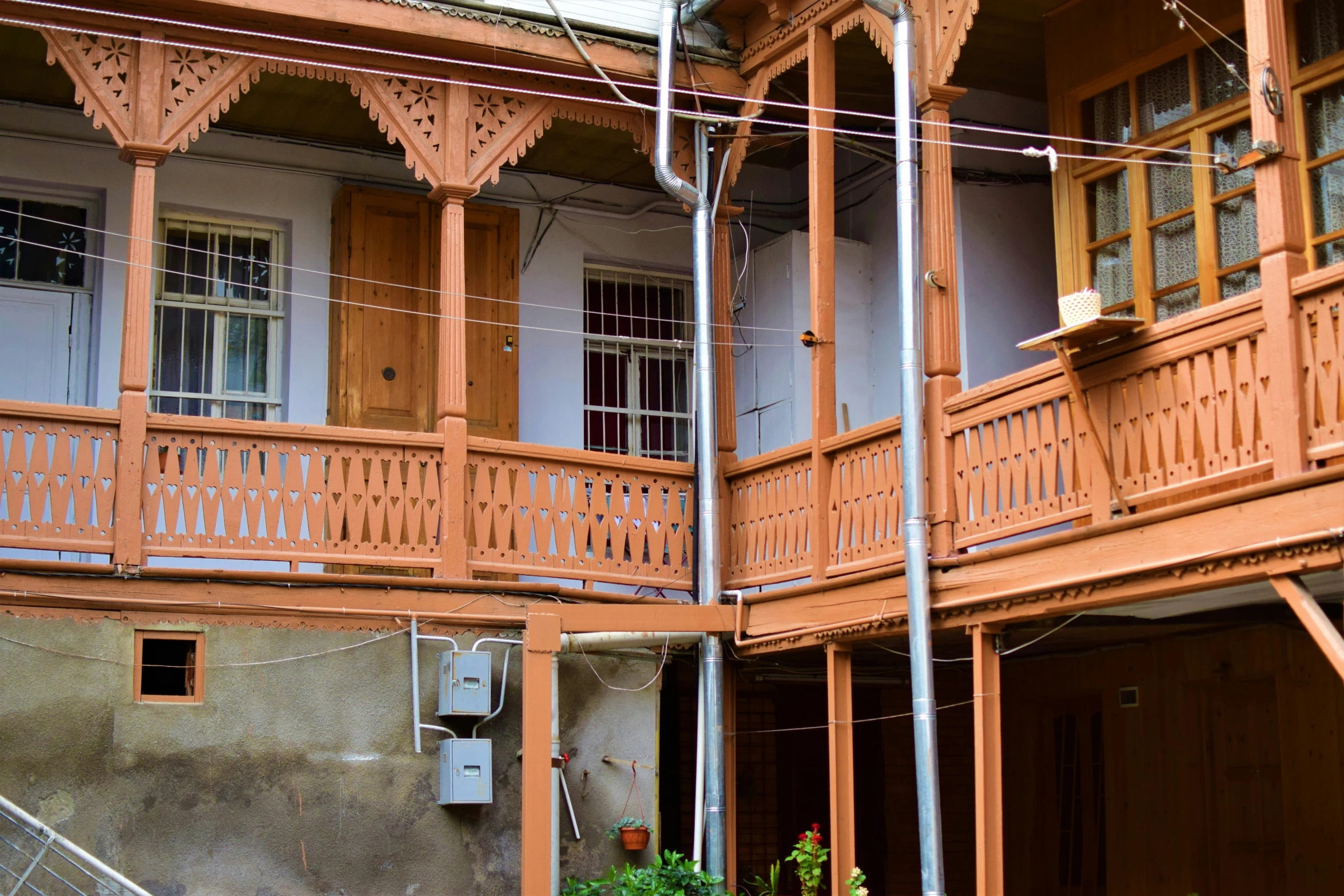 two story house with a balcony and balconies and green plants