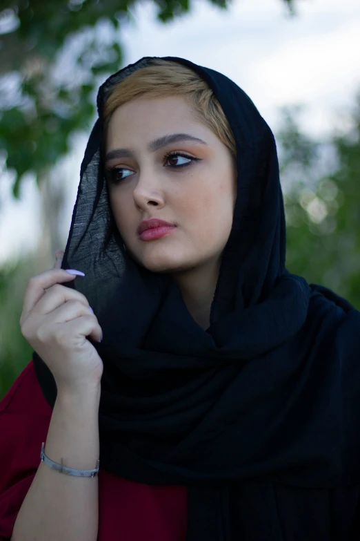 a woman holding onto her cell phone while wearing a hijab