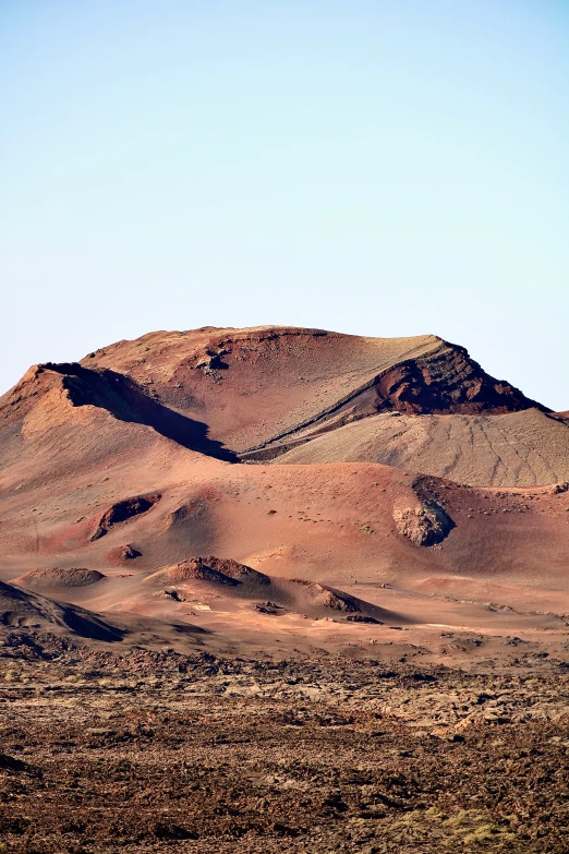 some brown rocks and grass and a mountain