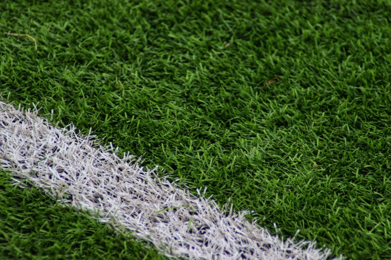 a closeup of the white line on a green artificial grass field