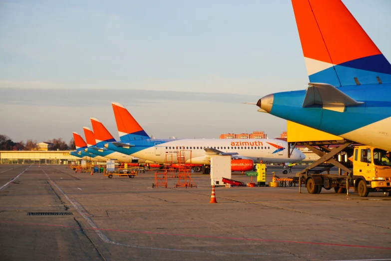 many colorful airplanes parked on the tarmac