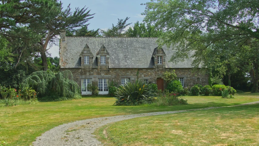 a stone house surrounded by lush green trees