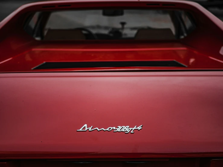 the front end of a red car with an emblem on it