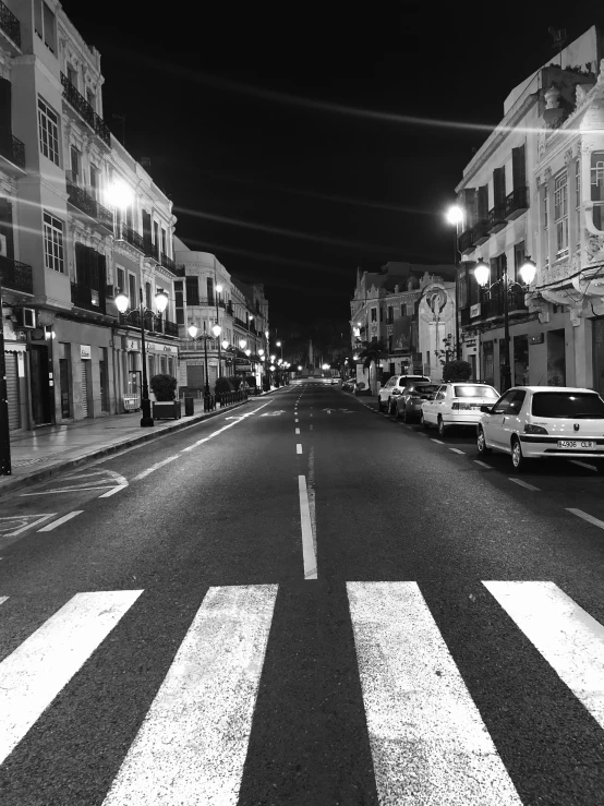 a street in front of some buildings with lights on it