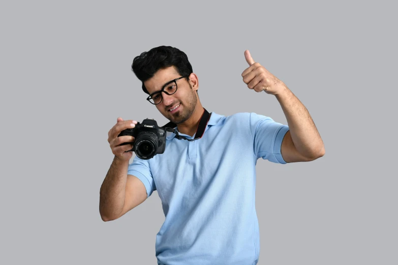 a man in glasses and a blue shirt holding a camera