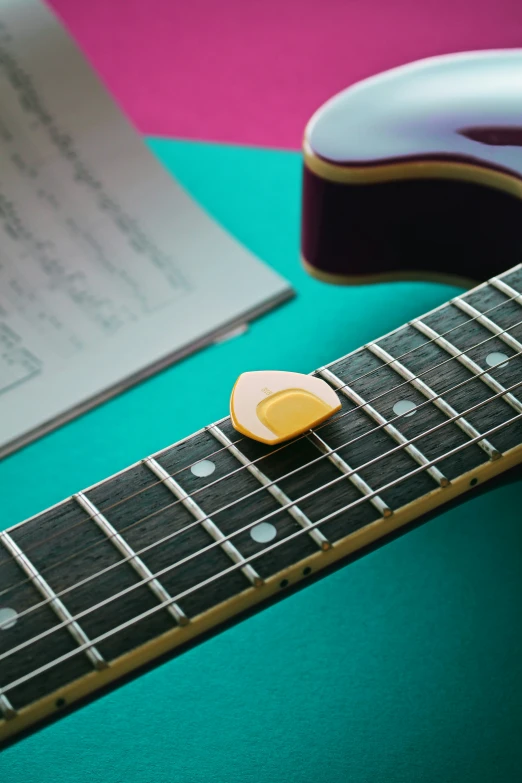 a guitar with the pickled up and a piece of yellow