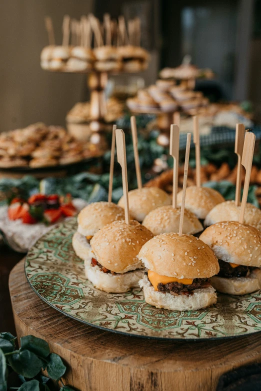 miniature burgers on stick with toothpicks are on a tray