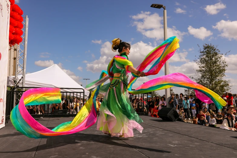 a colorfully dressed woman is performing in front of an audience