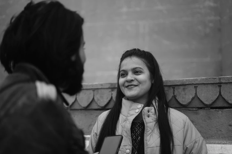 a black and white po of a girl smiling at another person