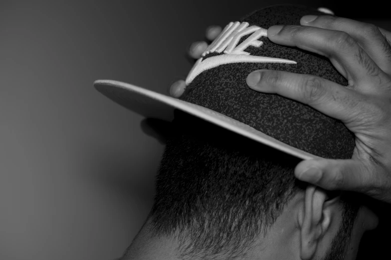 the man is wearing a hat while getting ready to shave his hair