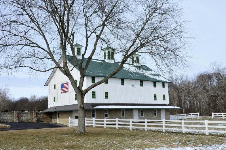 the large building is next to the tree and fence