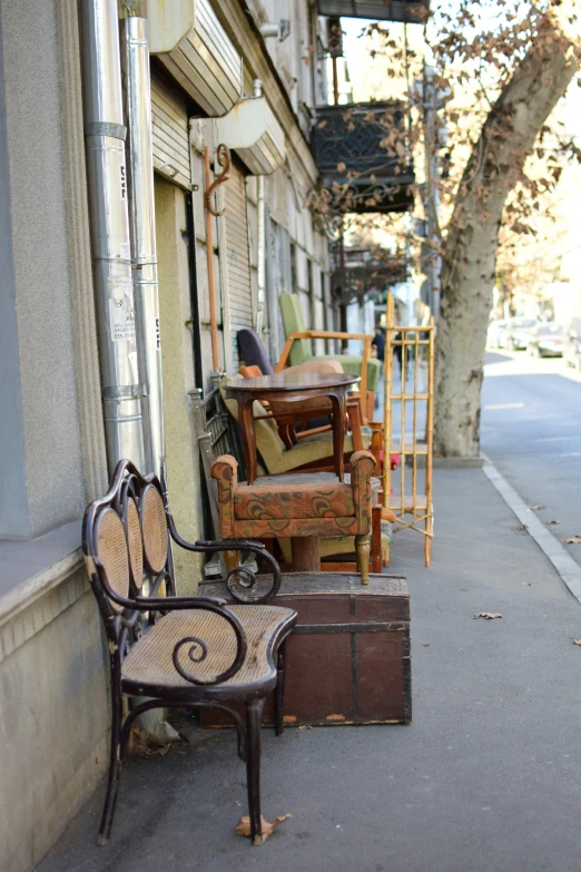 three wooden chairs, one with some paint, sit next to a wall