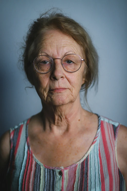 an elderly woman in glasses posing for the camera