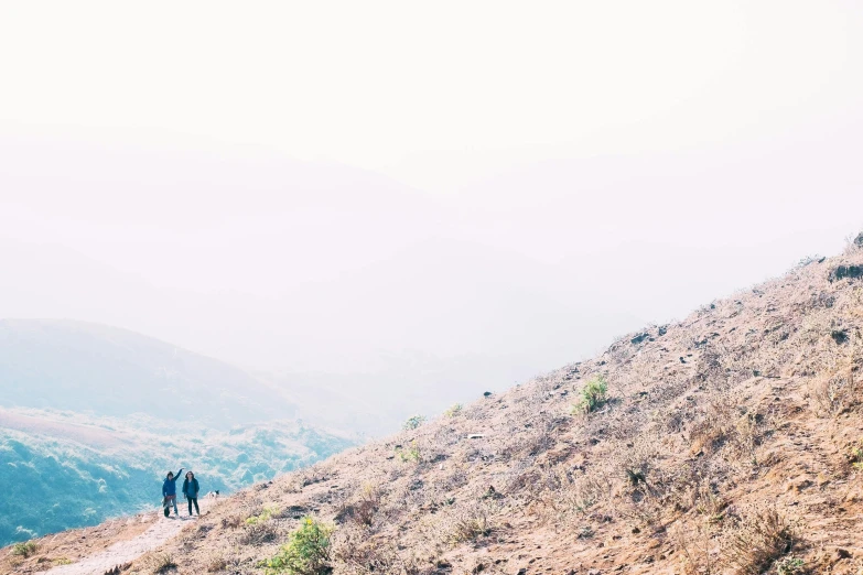 the people are standing on top of the hill