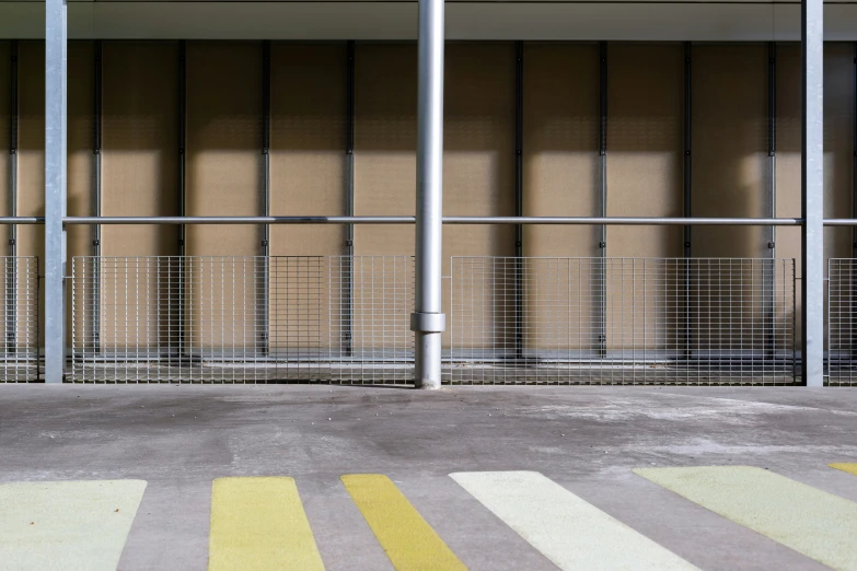 a bus stop with striped flooring next to metal bars