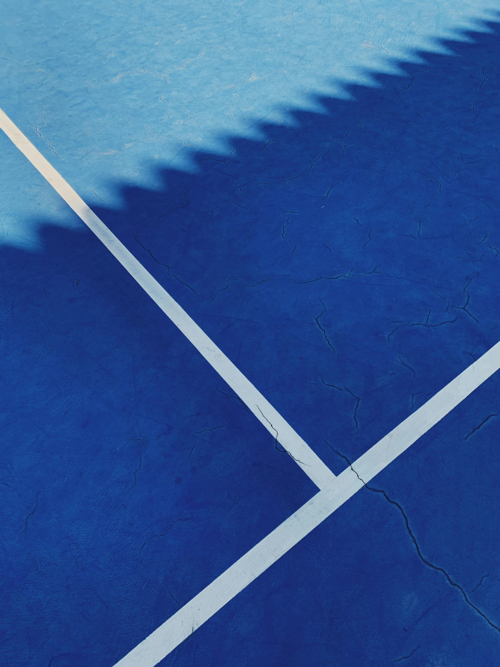 an image of the shadows of tennis rackets on a tennis court