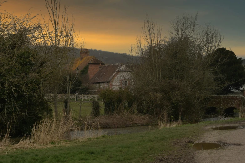 there is an old building behind trees and grass