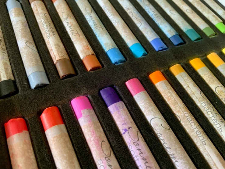the many different colored crayons have writing on them