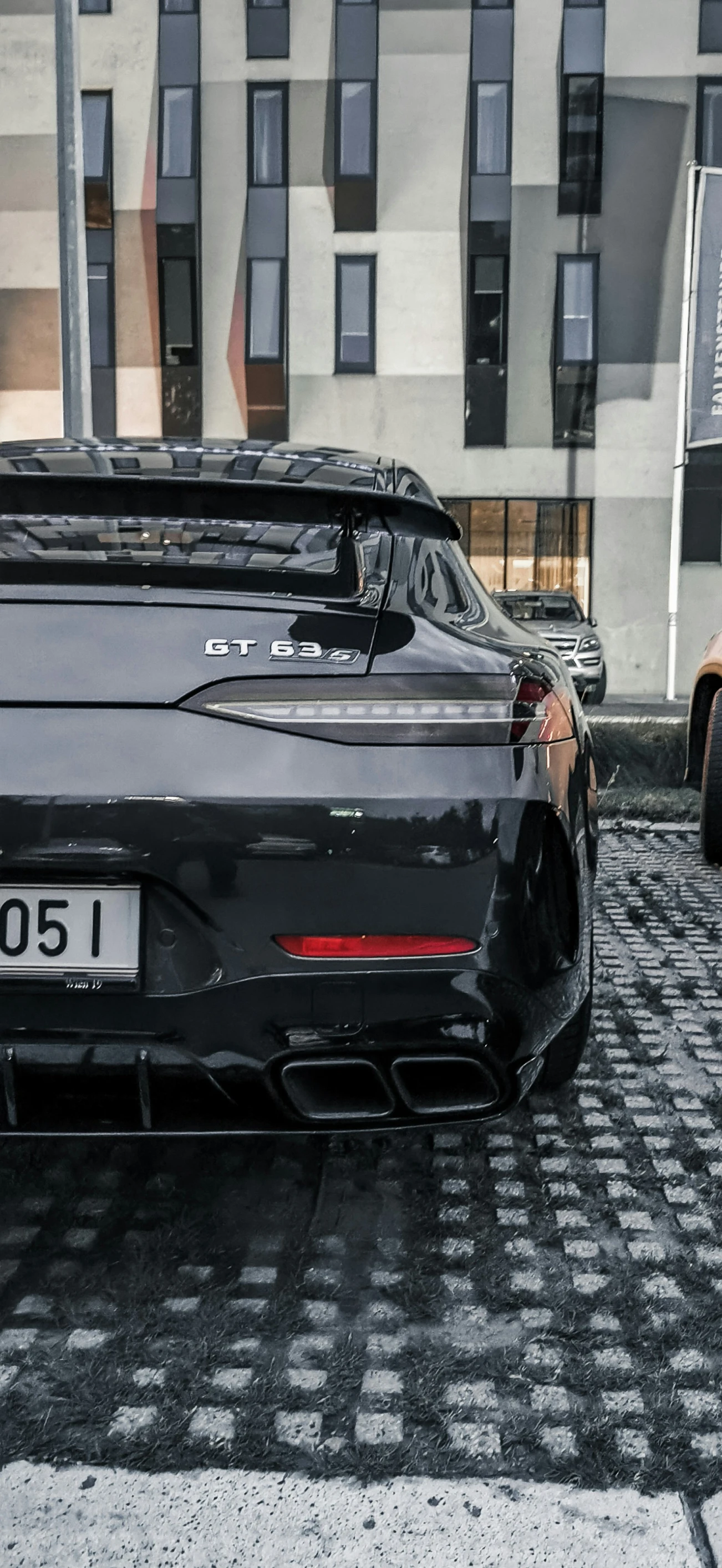 two different sports cars parked on a city street