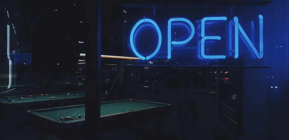 a large open sign hanging from the side of a building