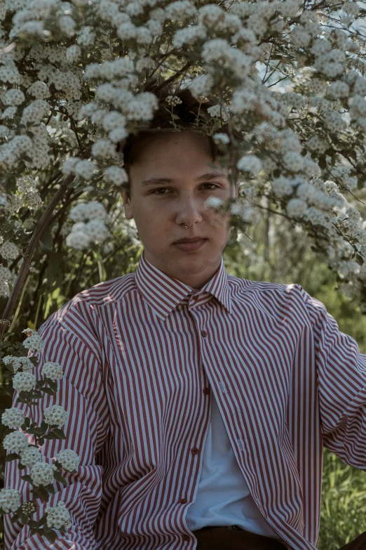 a person that is standing under some white flowers