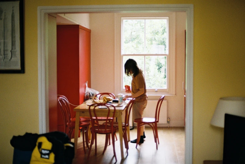 a person standing at a kitchen table with a book in hand