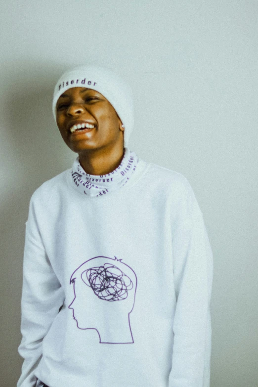 young man smiling while wearing an oversized in sweater