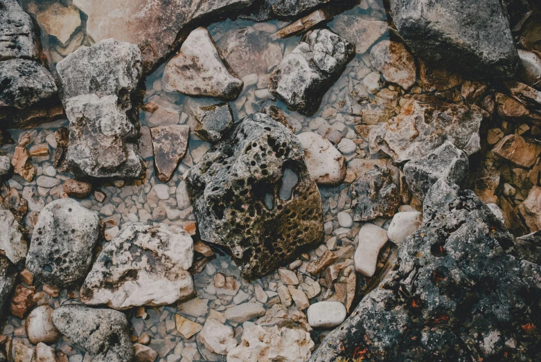 rocks and grass sitting on top of a rocky field