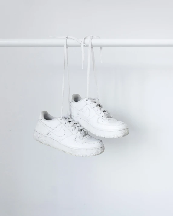 white shoes hanging from a pair of white string