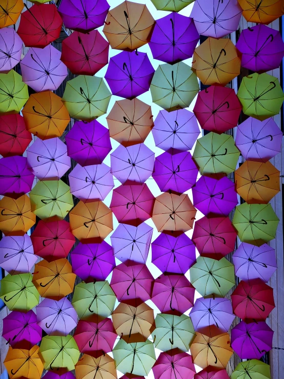 several colorful umbrellas are set up in a square pattern