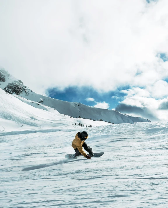 a snow boarder riding down a snowy slope