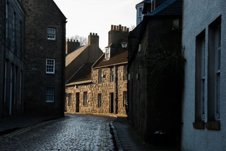 a narrow alley way with small houses in the background