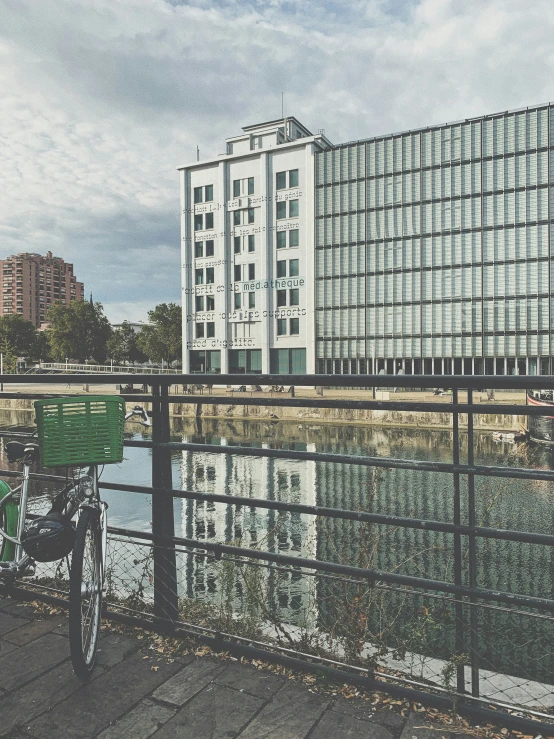 a bicycle locked on a railing next to water