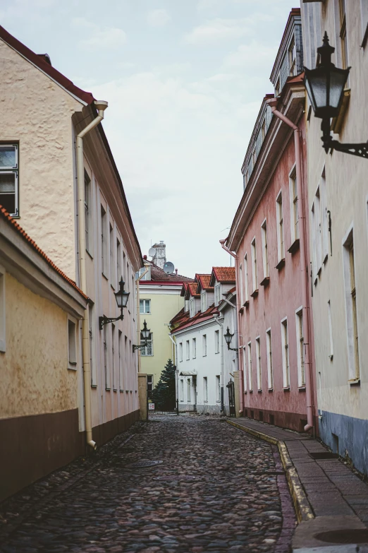 a narrow city street lined with pink buildings