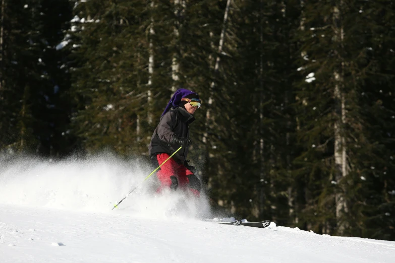 a snow skier going down the mountain near trees