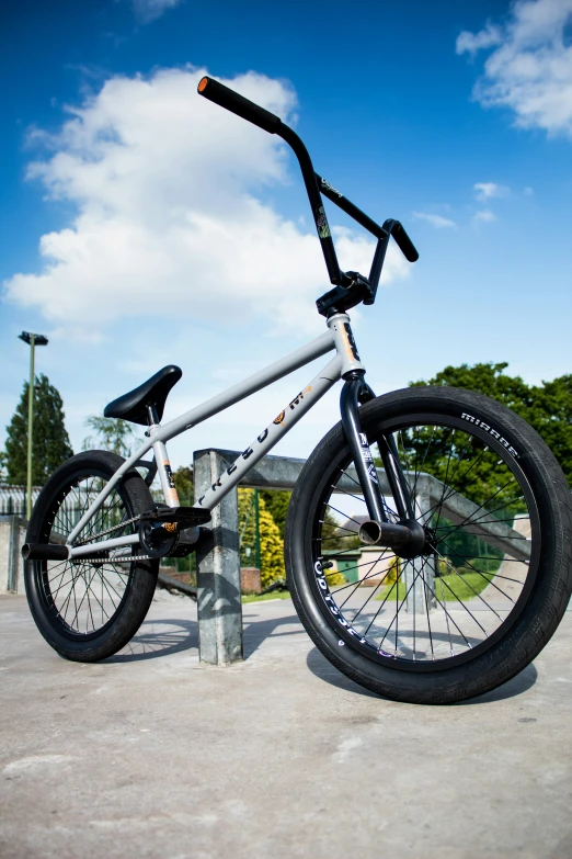 a gray and black bike parked next to a metal pole