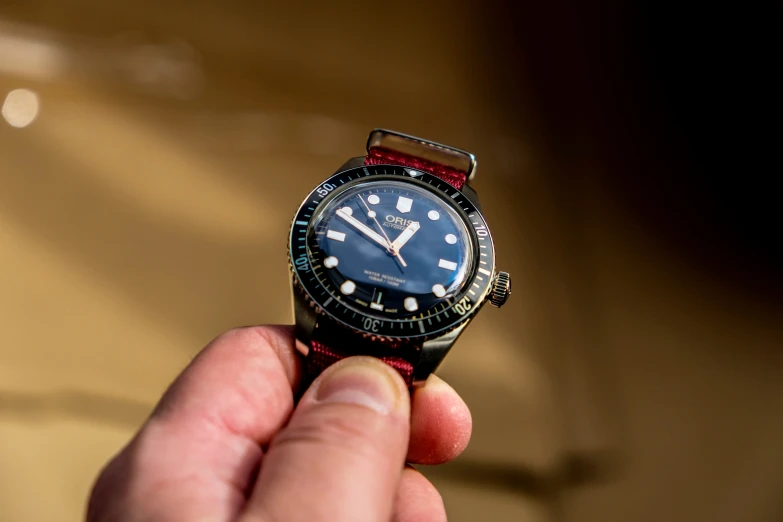 a person holding up a watch in their left hand