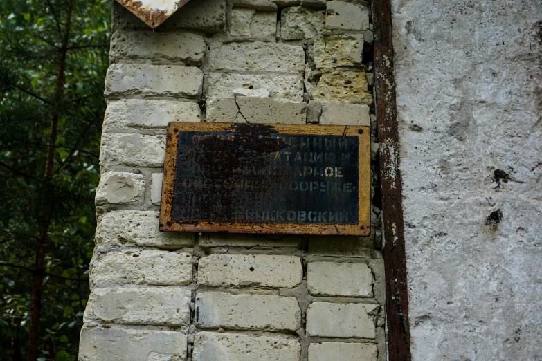 a sign is on a stone building with a brown frame